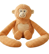 Weighted small monkey hugger toy sitting upright facing front on a white background